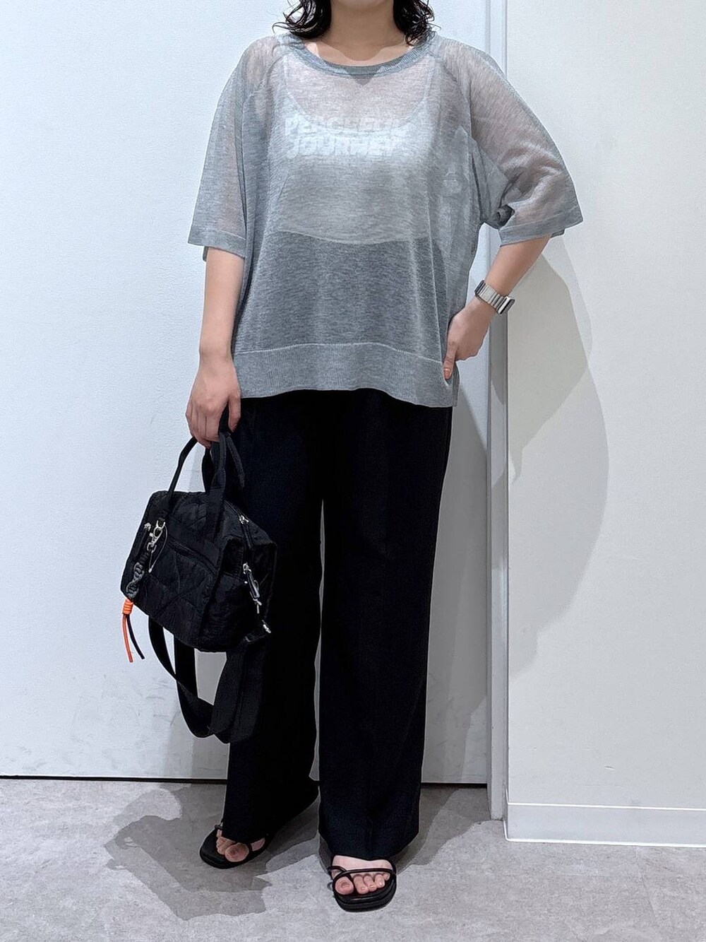 グレー系のニット/セーター、ブラック系のその他パンツ、ブラック系のボストンバッグを着用したレディースの夏コーディネートの4枚目の写真