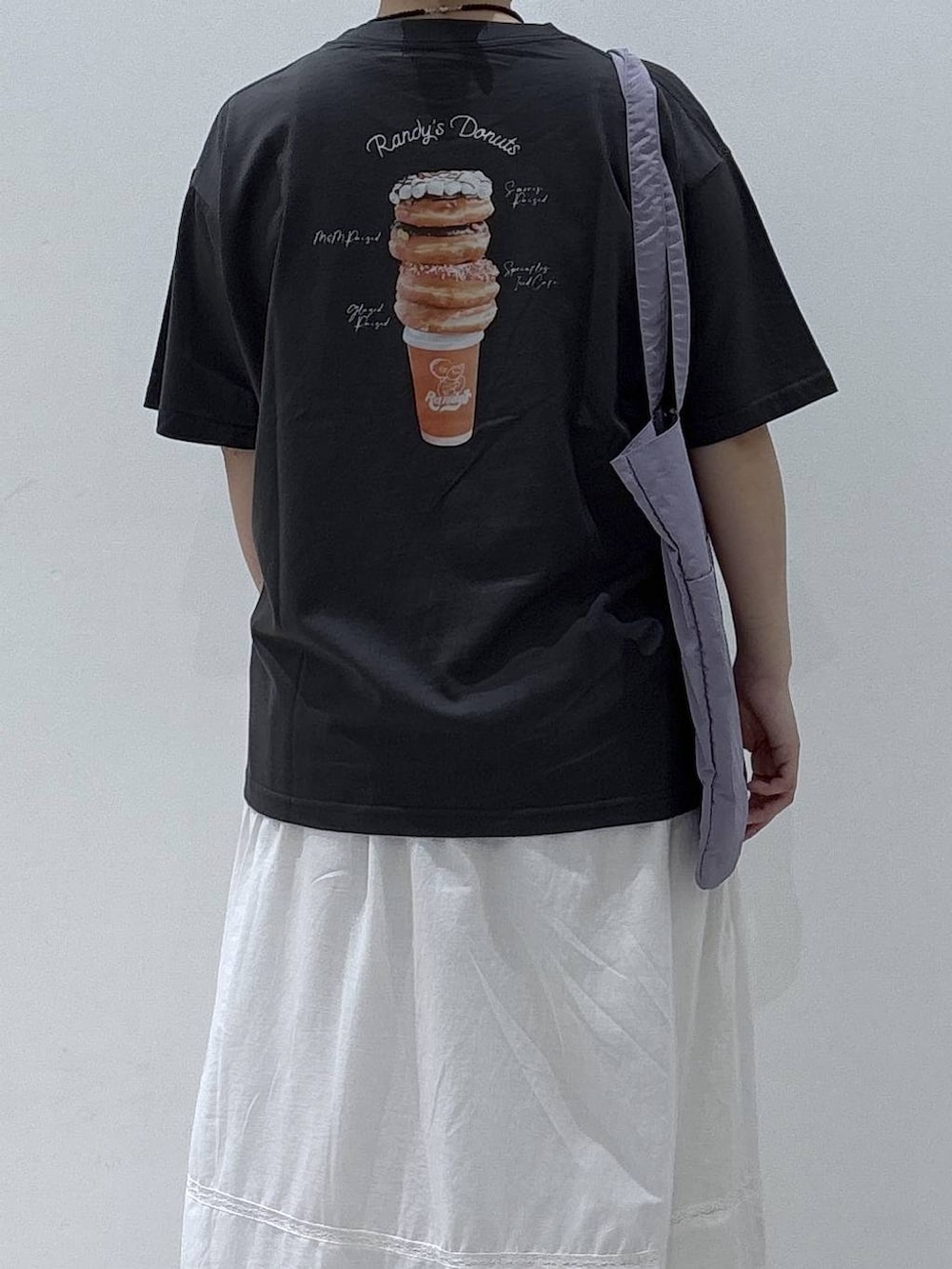 ホワイト系のスカート、パープル系のトートバッグ、グレー系のTシャツ/カットソーを着用したレディースの夏コーディネートの4枚目の写真