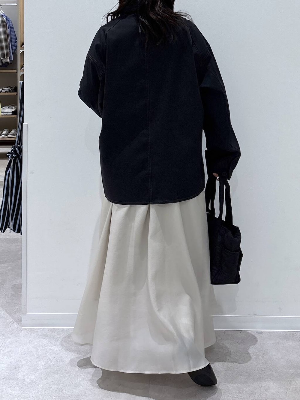 ブラック系のバレエシューズ、ブラック系のトートバッグ、ベージュ系のスカートを着用したレディースの春コーディネートの3枚目の写真