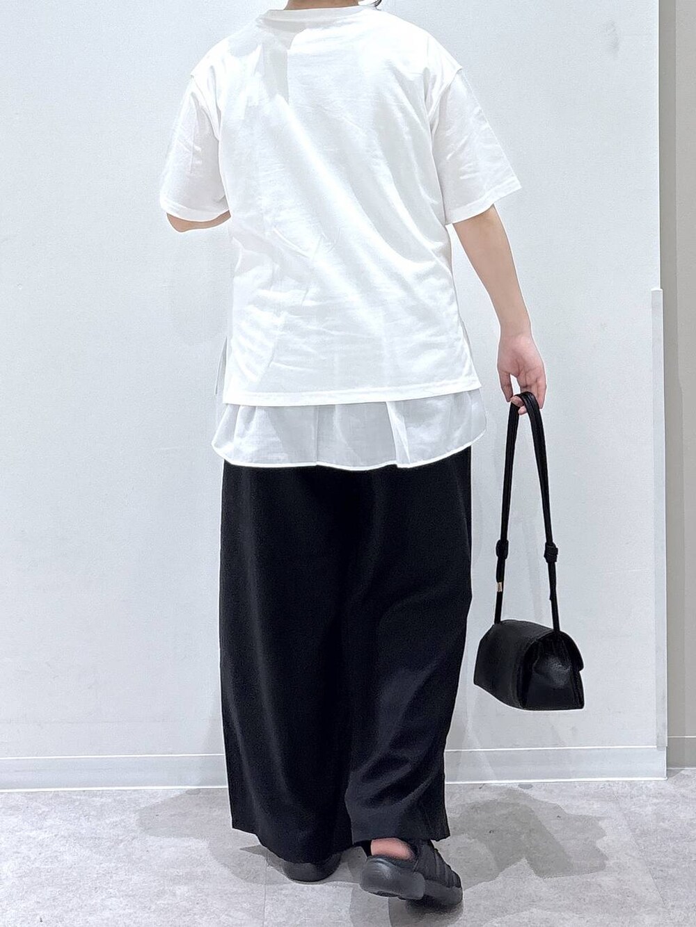 ブラック系のショルダーバッグ、ブラック系のその他パンツ、ホワイト系のタンクトップを着用したレディースの夏コーディネートの2枚目の写真