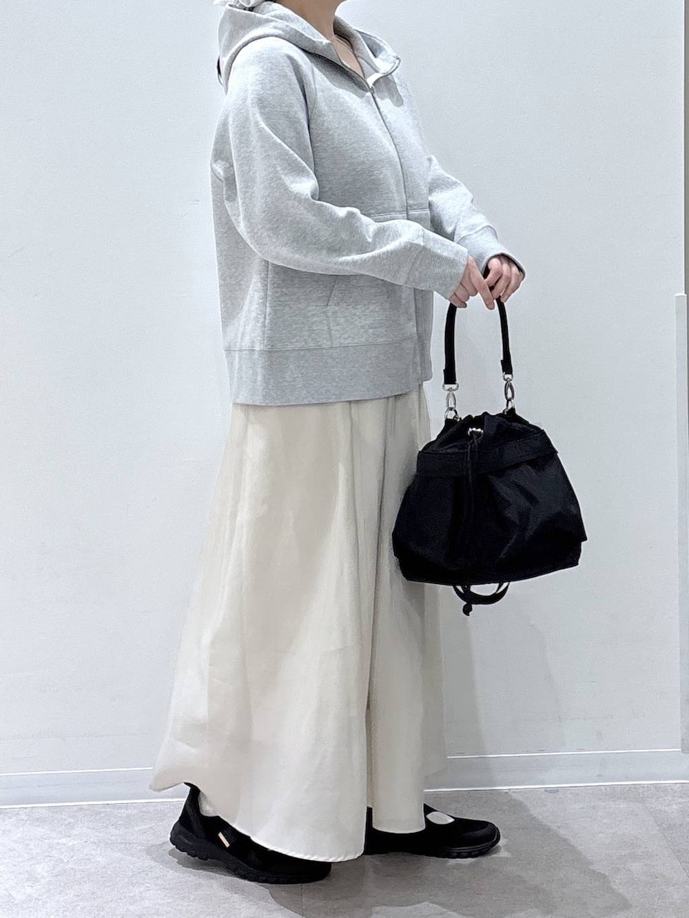 ブラック系のスニーカー、ブラック系のショルダーバッグ、グレー系のパーカーを着用したレディースの春コーディネートの2枚目の写真
