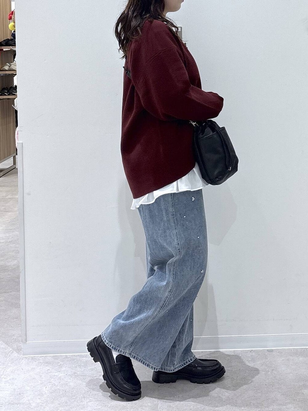 ブラック系のローファー、ブルー系のデニムパンツ、ホワイト系のTシャツ/カットソーを着用したレディースの秋コーディネートの2枚目の写真