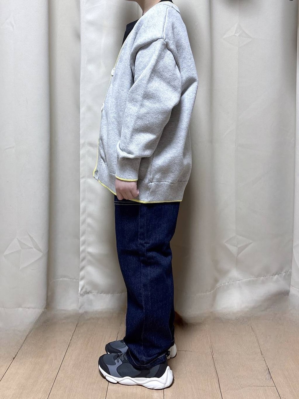 ブラック系のスニーカー、ブルー系のデニムパンツ、ブラック系のTシャツ/カットソーを着用したキッズの冬コーディネートの2枚目の写真