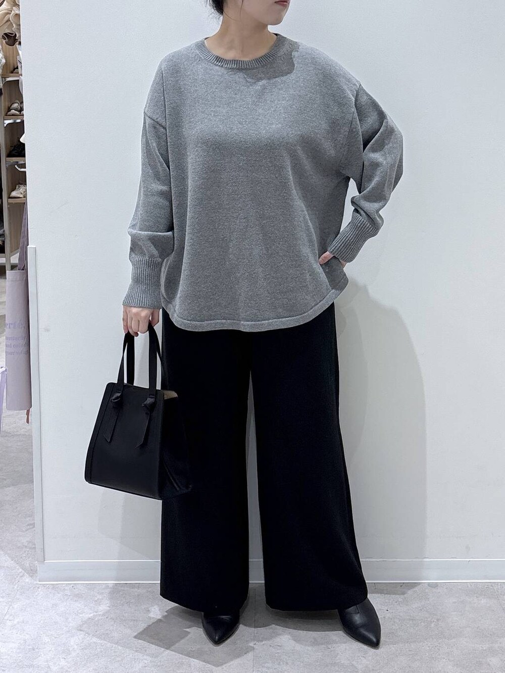 ブラック系のショルダーバッグ、グレー系のニット/セーター、その他のチェスターコートを着用したレディースの冬コーディネートの4枚目の写真