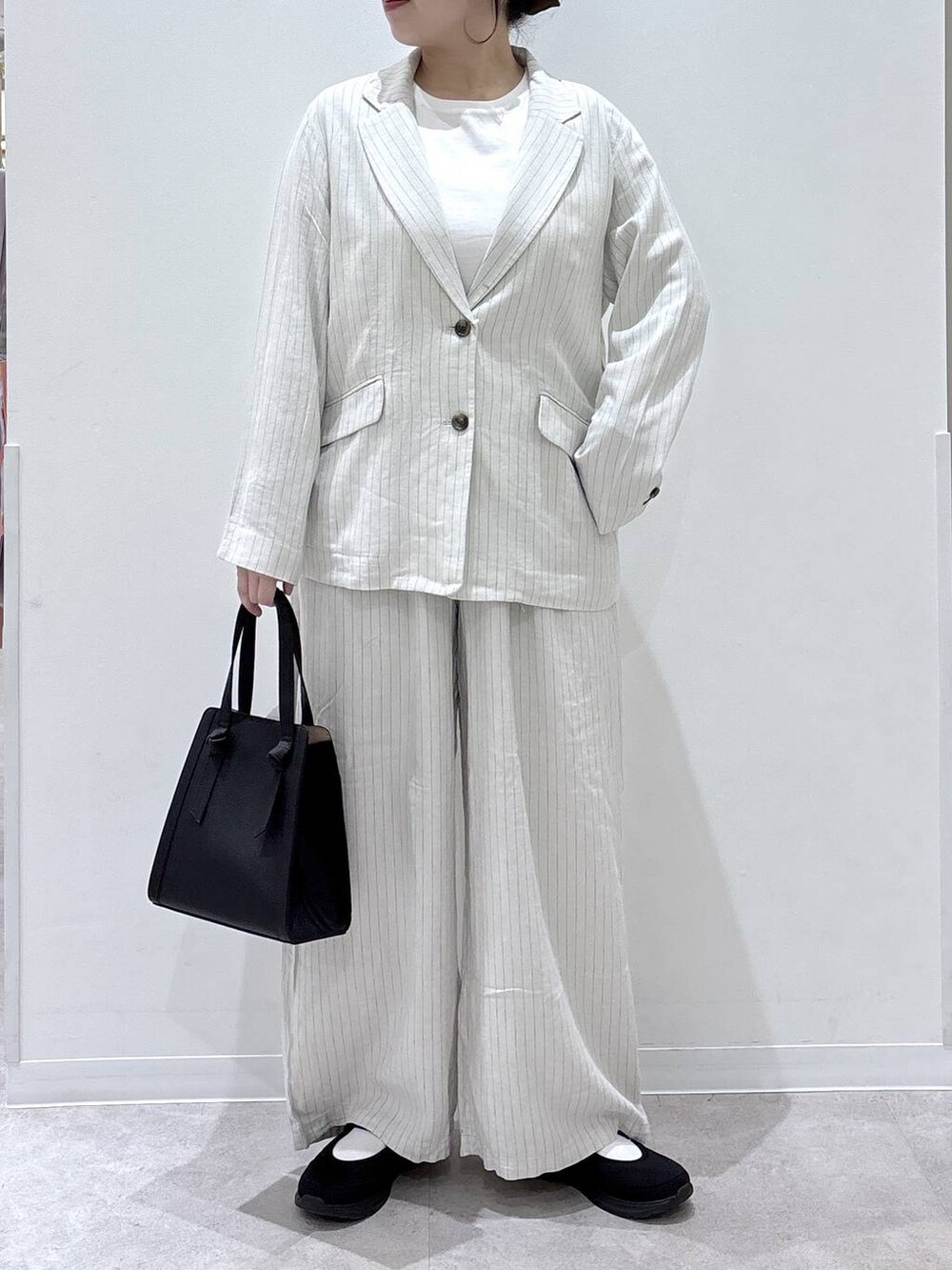 ブラック系のショルダーバッグ、ベージュ系のその他パンツ、ブラック系のスニーカーを着用したレディースの春コーディネートの2枚目の写真