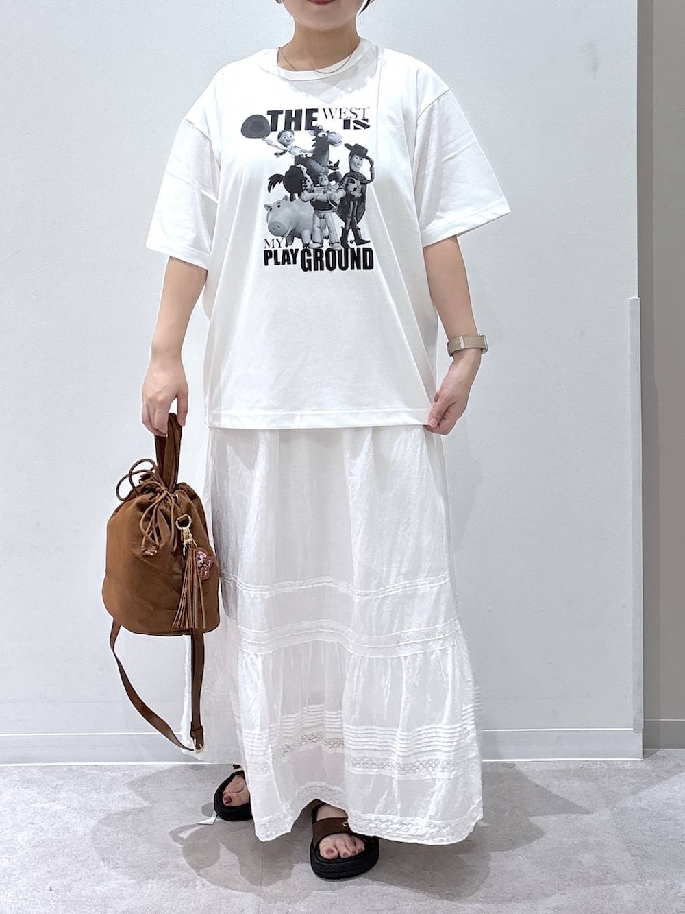 ベージュ系のハンドバッグ、ホワイト系のスカート、ホワイト系のTシャツ/カットソーを着用したレディースの夏コーディネートの4枚目の写真