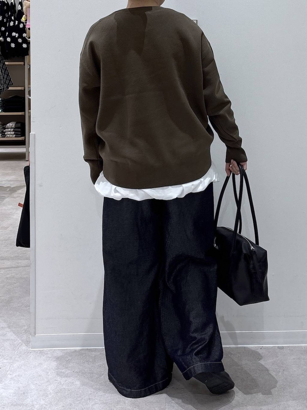 ブラック系のボストンバッグ、ホワイト系のTシャツ/カットソー、ブラウン系のニット/セーターを着用したレディースの秋コーディネートの3枚目の写真