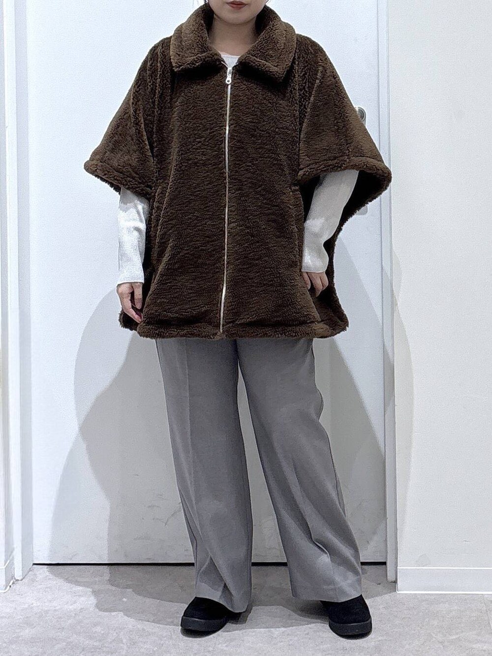 ベージュ系のニット/セーター、グレー系のその他パンツ、ブラウン系のポンチョを着用したレディースの秋コーディネートの5枚目の写真