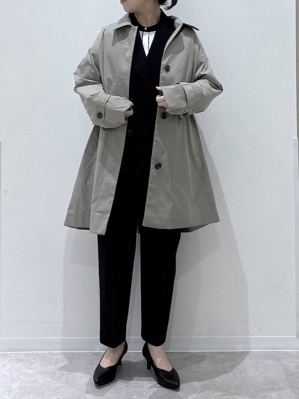 ブラック系のパンプス、ブラック系のスラックス、ホワイト系のシャツ/ブラウスを着用したレディースの冬コーディネートの4枚目の写真