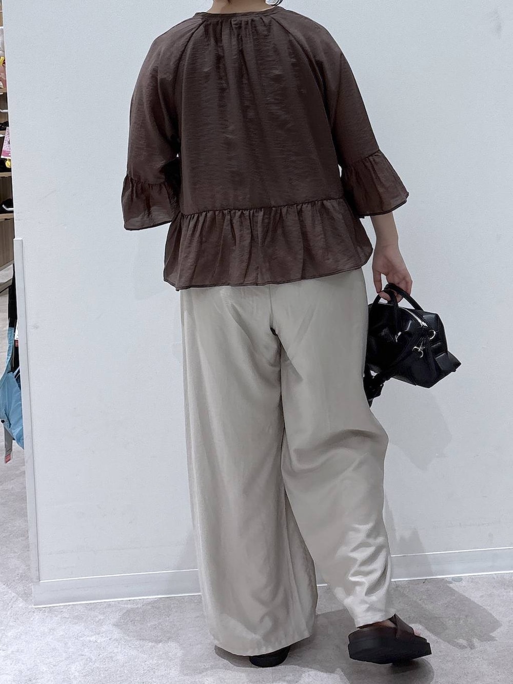 ベージュ系のその他パンツ、ブラック系のボストンバッグ、ブラウン系のカーディガン/ボレロを着用したレディースの夏コーディネートの3枚目の写真