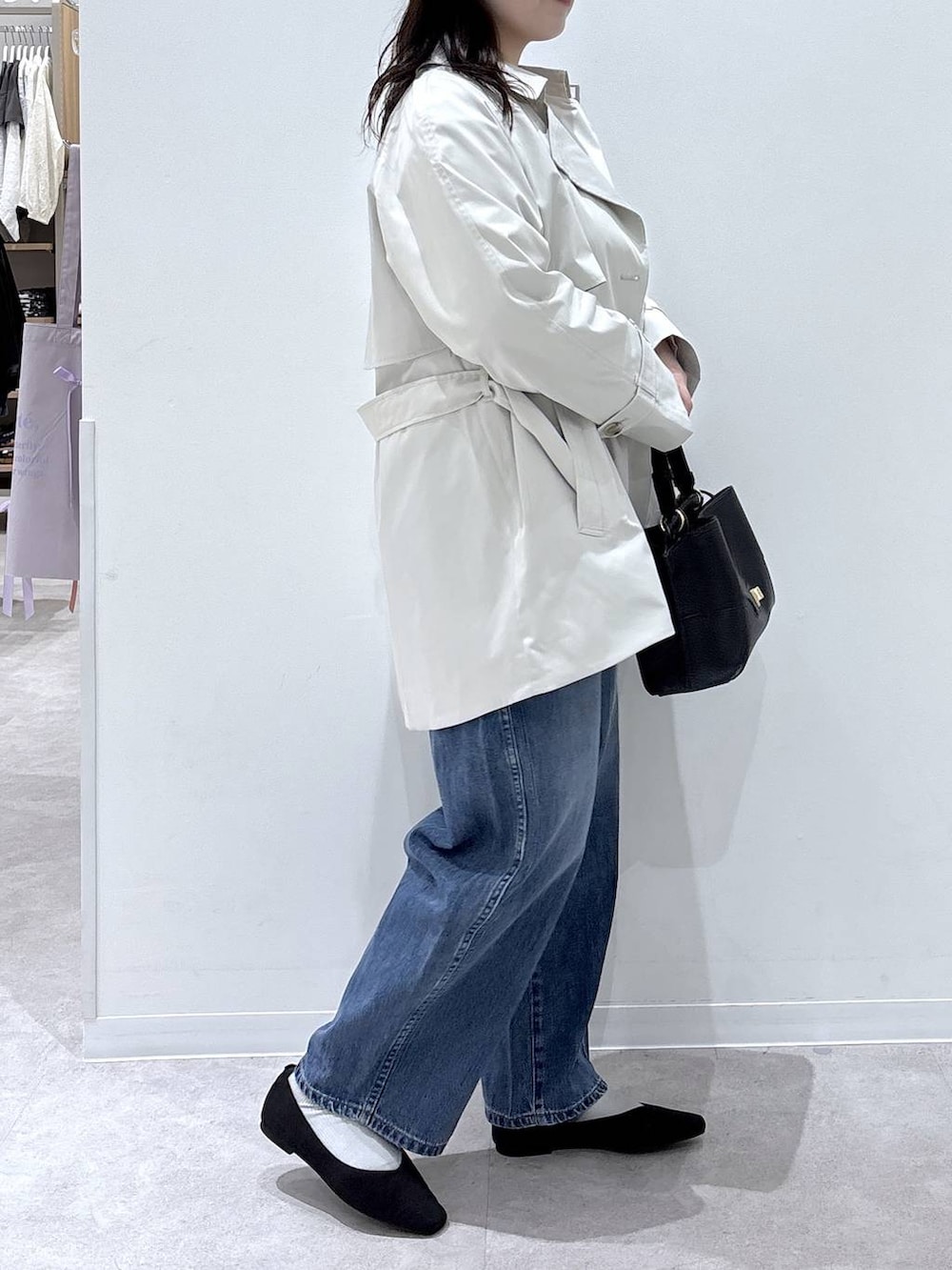 ブラック系のパンプス、ブルー系のデニムパンツ、ブラック系のショルダーバッグを着用したレディースの春コーディネートの2枚目の写真