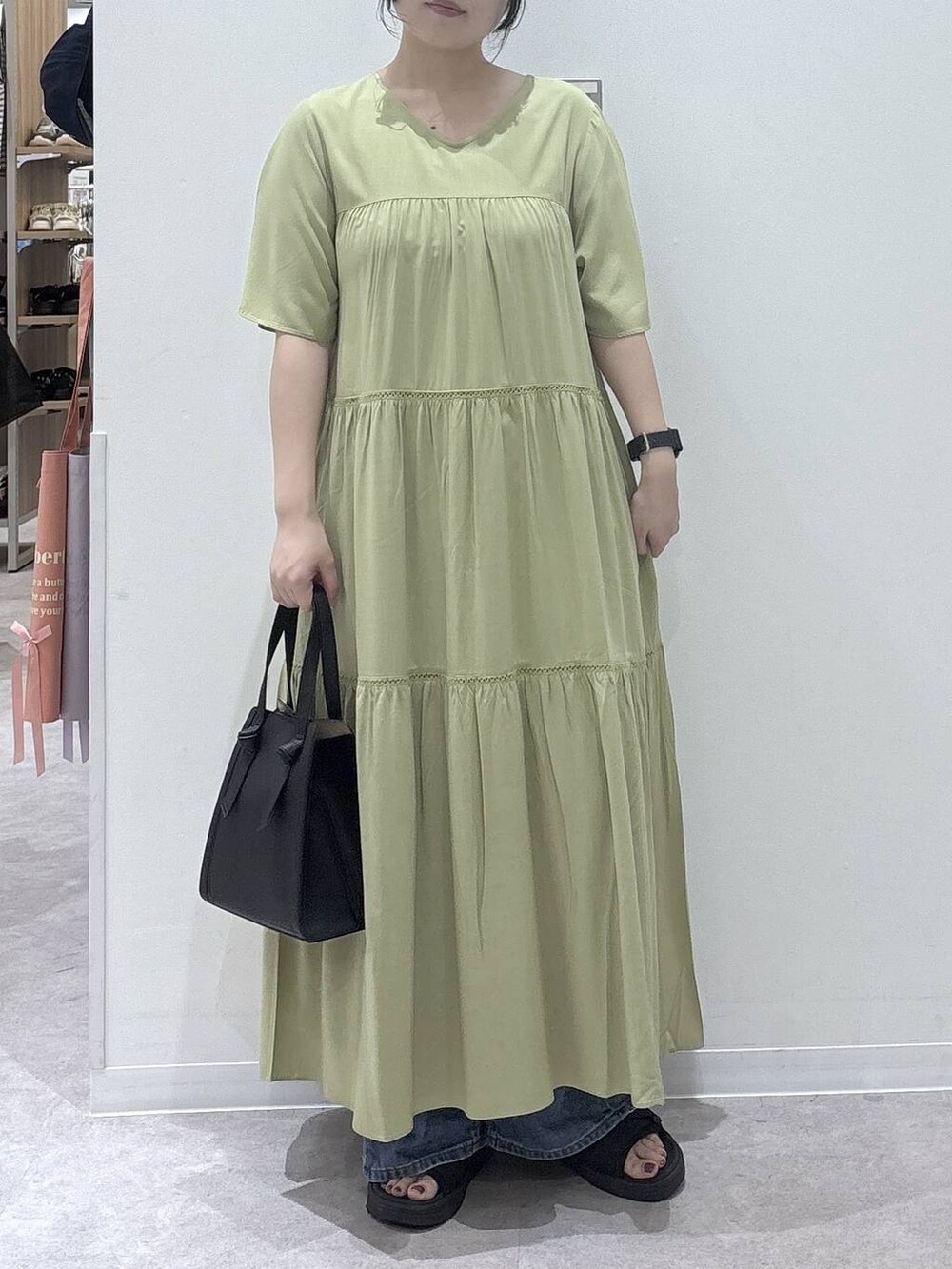 ブラック系のショルダーバッグ、ブルー系のデニムパンツ、ブラック系のサンダルを着用したレディースの夏コーディネートの4枚目の写真