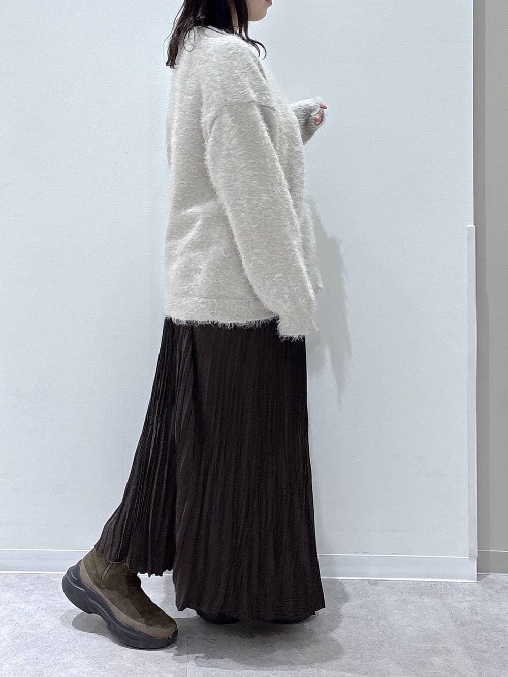 ブラウン系のブーツ、ベージュ系のカーディガン/ボレロ、ブラウン系のスカートを着用したレディースの冬コーディネートの2枚目の写真