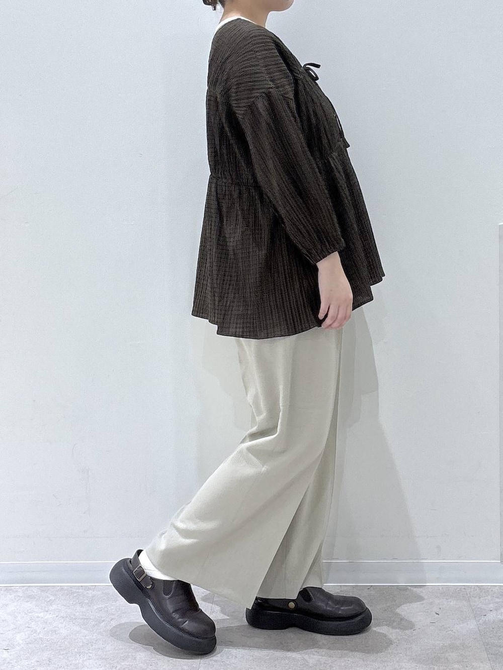 ベージュ系のその他パンツ、ブラウン系のカーディガン/ボレロを着用したレディースの春コーディネートの2枚目の写真