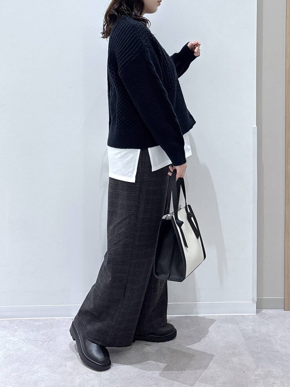 ホワイト系のショルダーバッグ、ホワイト系のTシャツ/カットソー、ブラック系のブーツを着用したレディースの秋コーディネートの2枚目の写真