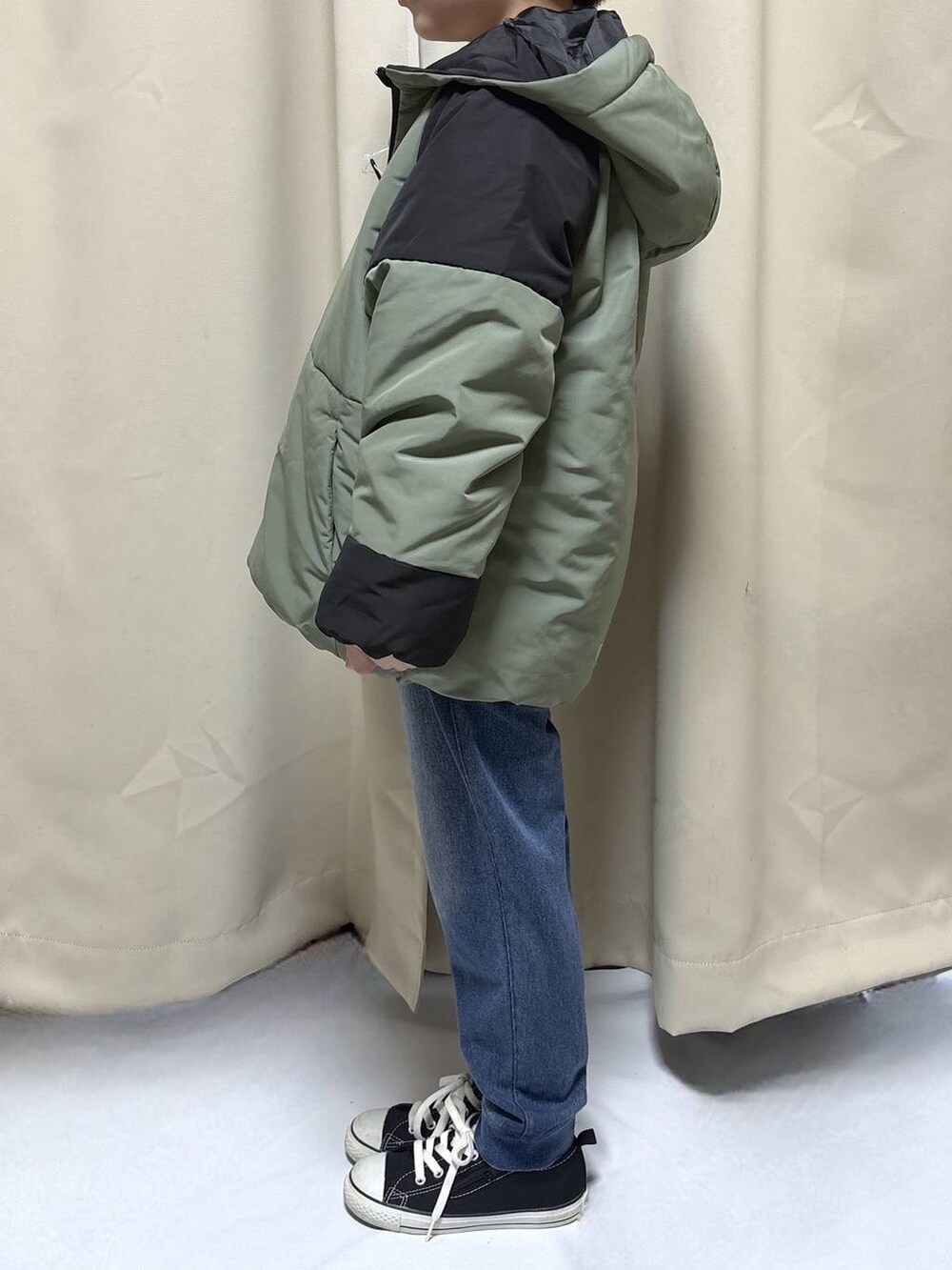 グリーン系のブルゾン、ブルー系のデニムパンツを着用したキッズの冬コーディネートの2枚目の写真