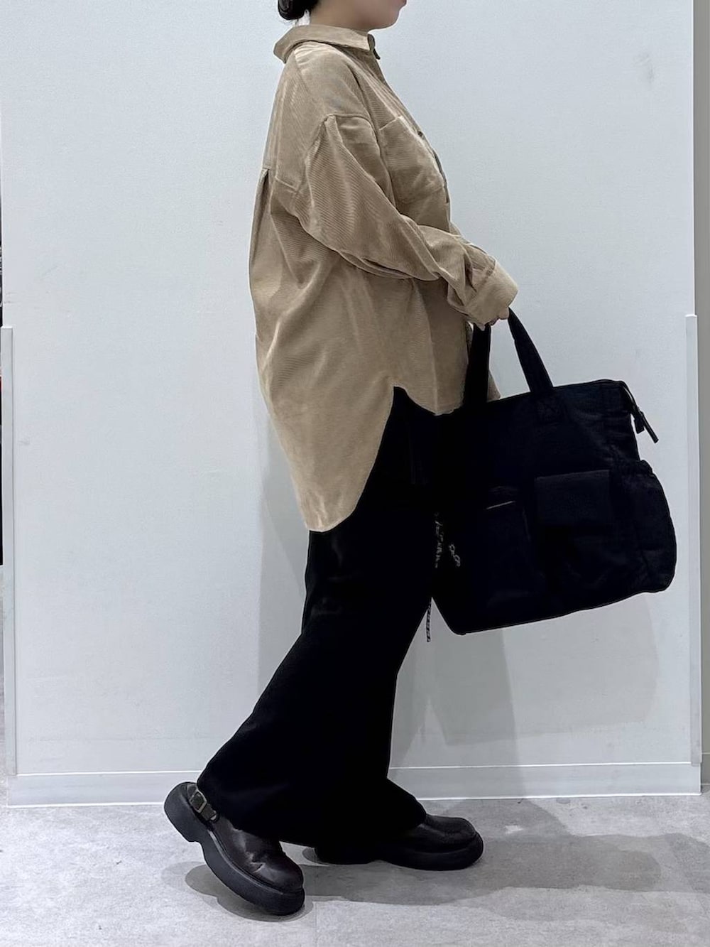 ブラック系のトートバッグ、ブラック系のその他パンツ、ブラウン系のシャツ/ブラウスを着用したレディースの秋コーディネートの2枚目の写真