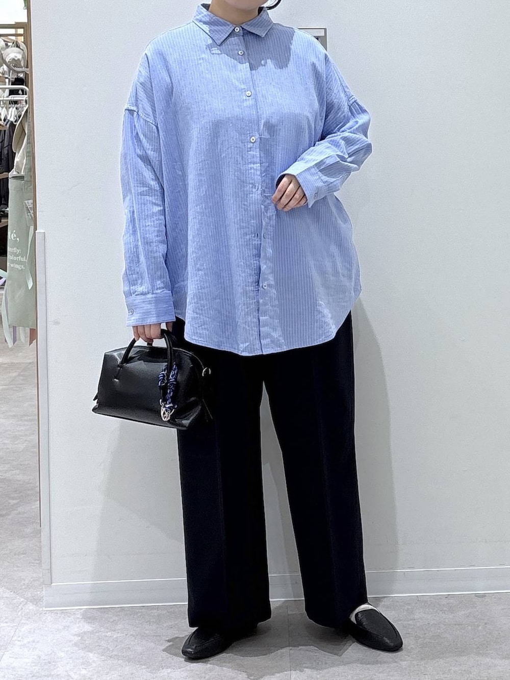 ブラック系のその他シューズ、ブラック系のボストンバッグ、ブルー系のシャツ/ブラウスを着用したレディースの春コーディネートの4枚目の写真