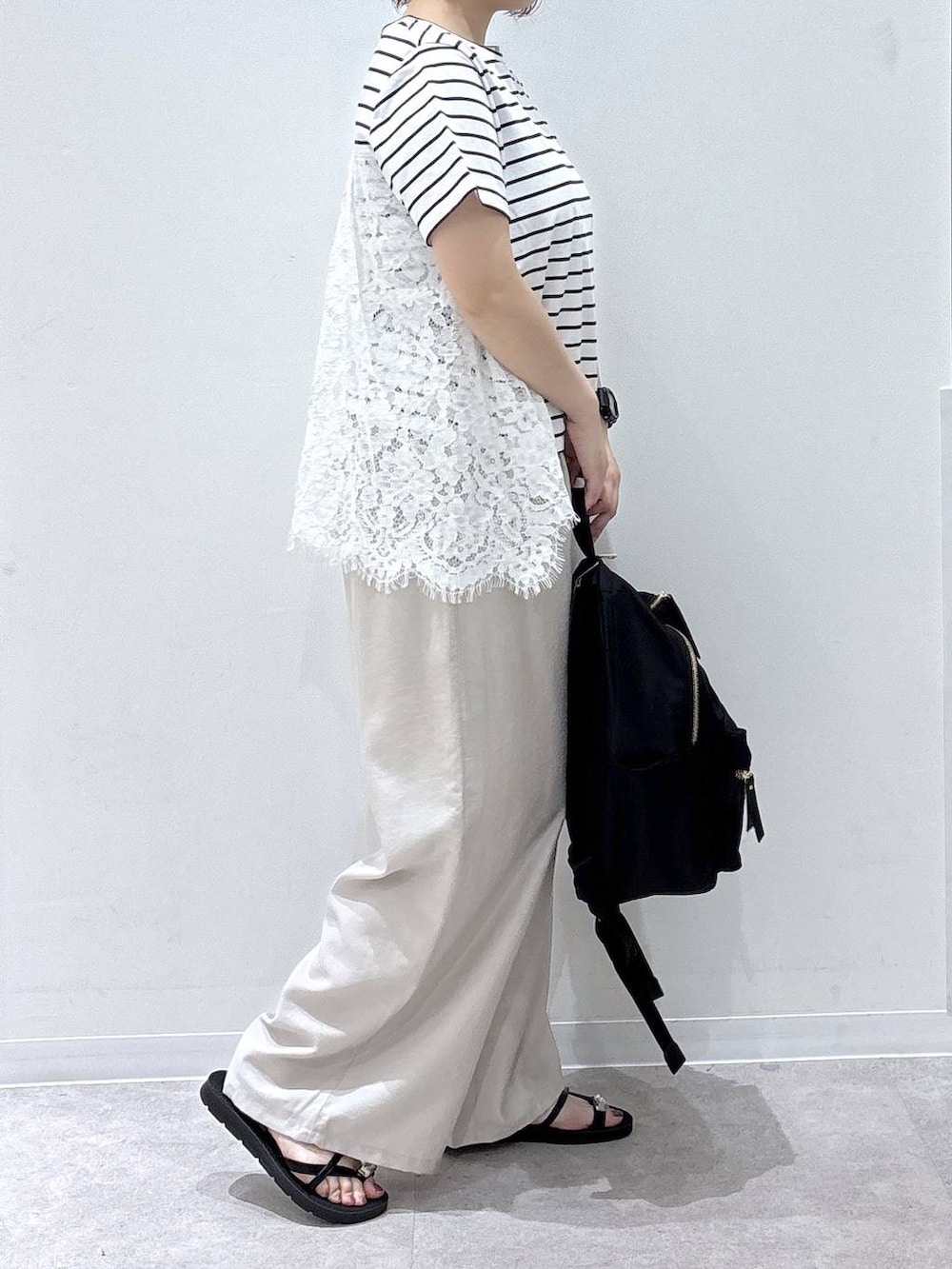 ブラック系のバックパック/リュック、ベージュ系のその他パンツ、ホワイト系のTシャツ/カットソーを着用したレディースの夏コーディネートの2枚目の写真