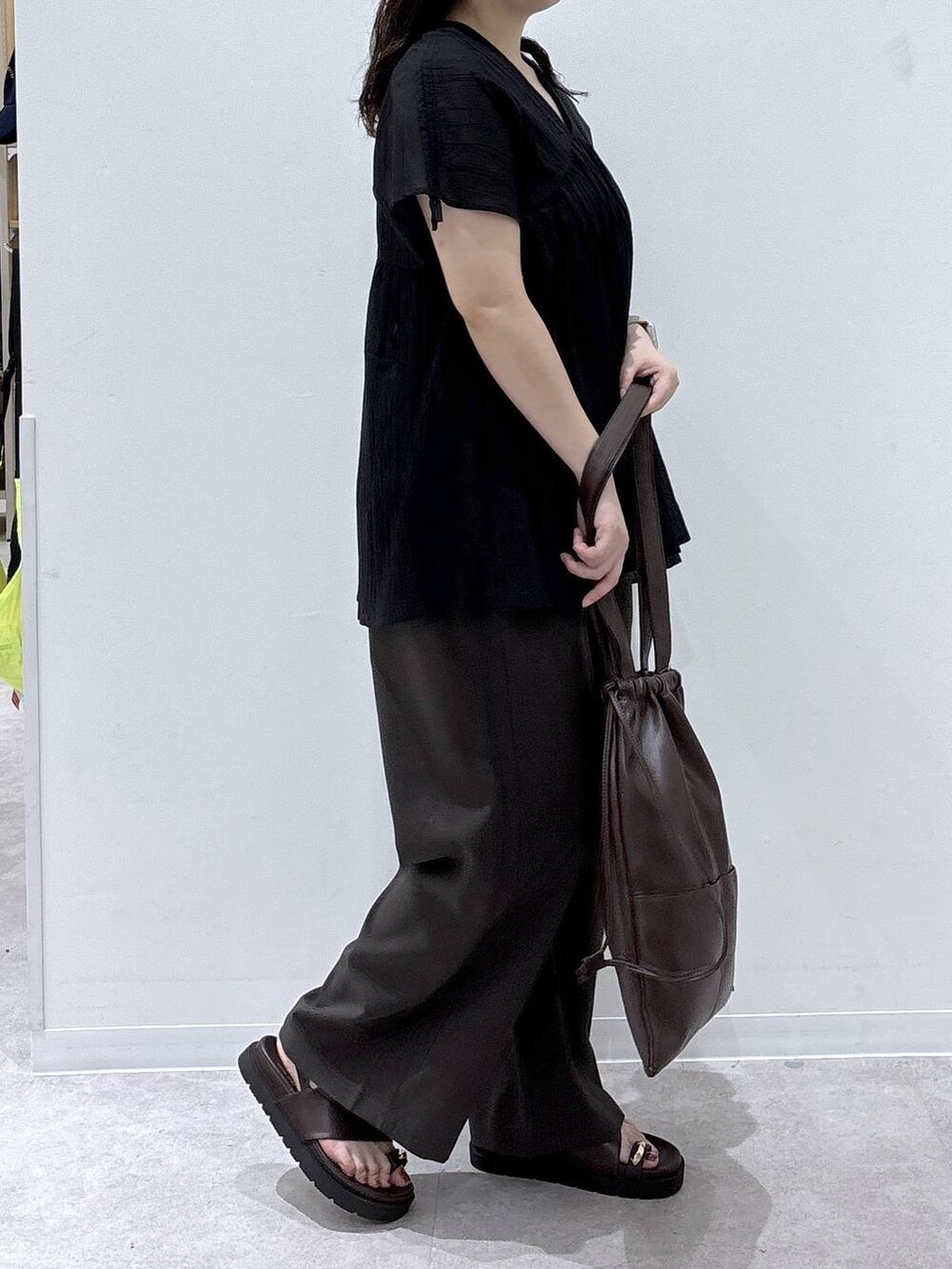 ブラウン系のその他パンツ、ブラック系のシャツ/ブラウス、ブラック系のサンダルを着用したレディースの夏コーディネートの2枚目の写真