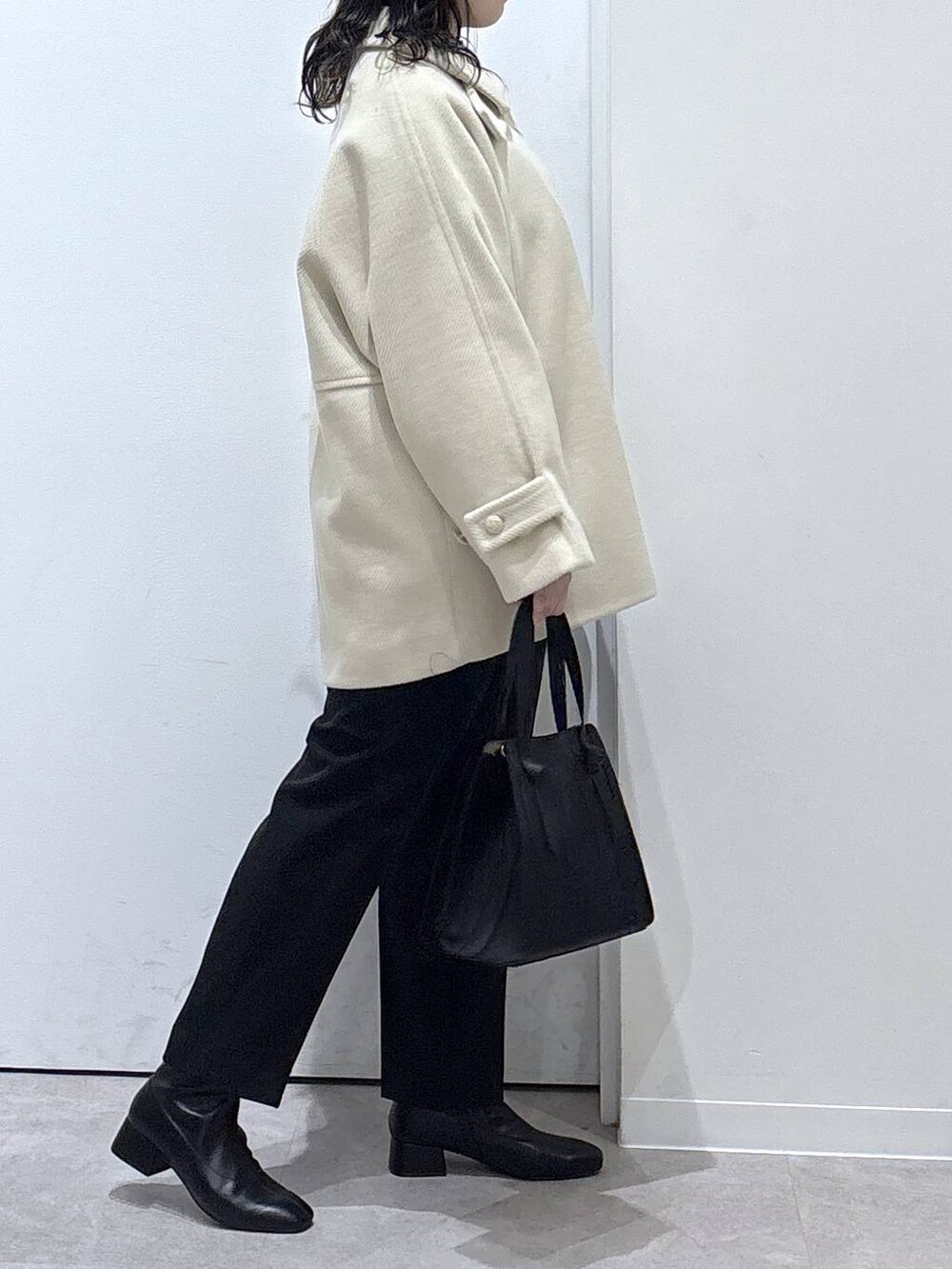 ブラック系のショルダーバッグ、ブラック系のその他パンツ、ホワイト系のステンカラーコートを着用したレディースの秋コーディネートの2枚目の写真