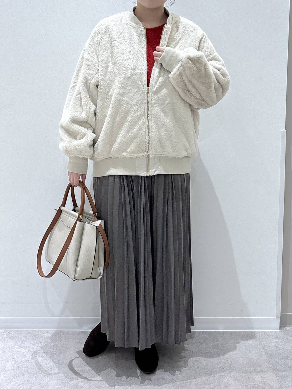 ベージュ系のブルゾン、ベージュ系のスカート、レッド系のニット/セーターを着用したレディースの冬コーディネートの4枚目の写真