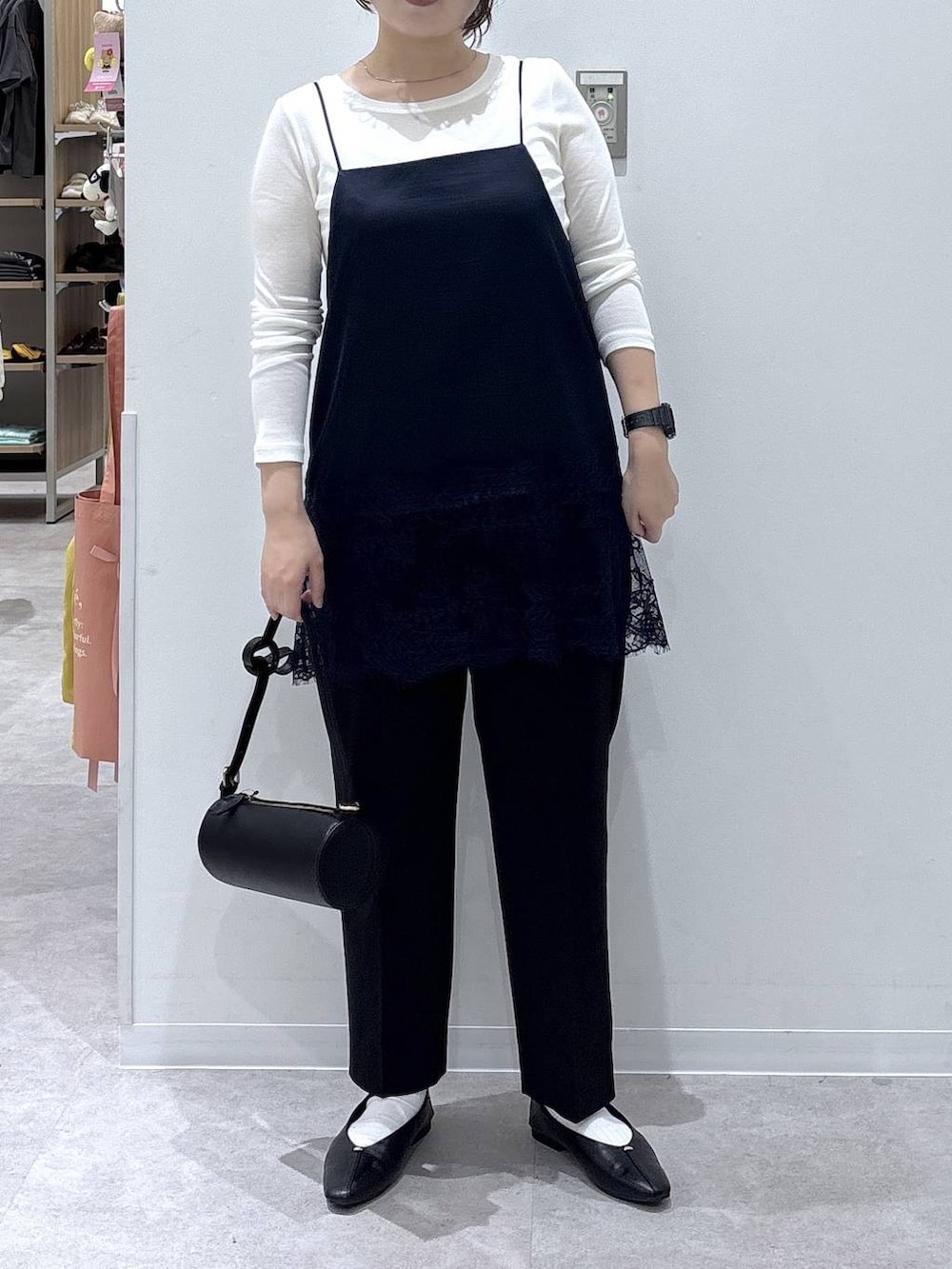 ブラック系のパンプス、ブラック系のクラッチバッグ、ホワイト系のTシャツ/カットソーを着用したレディースの秋コーディネートの3枚目の写真