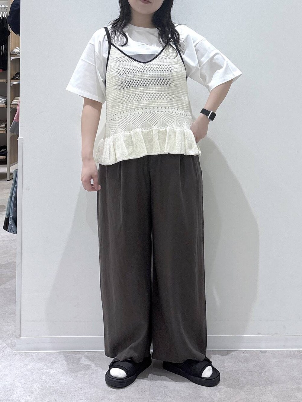 ブラウン系のその他パンツ、ホワイト系のTシャツ/カットソー、ブラック系のサンダルを着用したレディースの春コーディネートの4枚目の写真