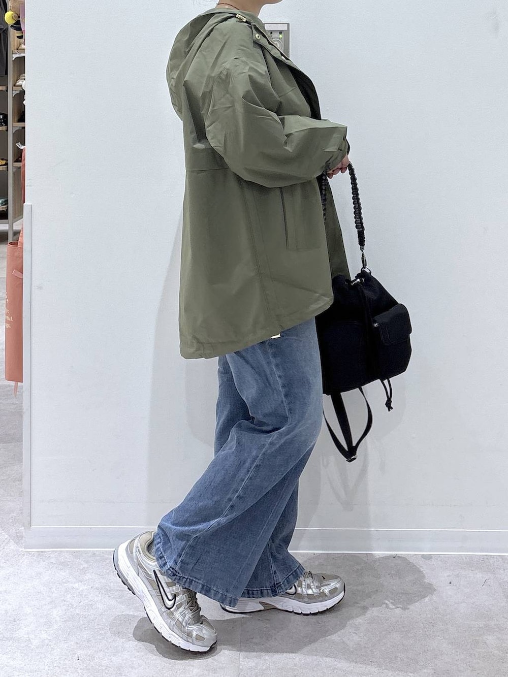 ブルー系のデニムパンツ、ホワイト系のTシャツ/カットソー、グリーン系のマウンテンパーカーを着用したレディースの秋コーディネートの2枚目の写真