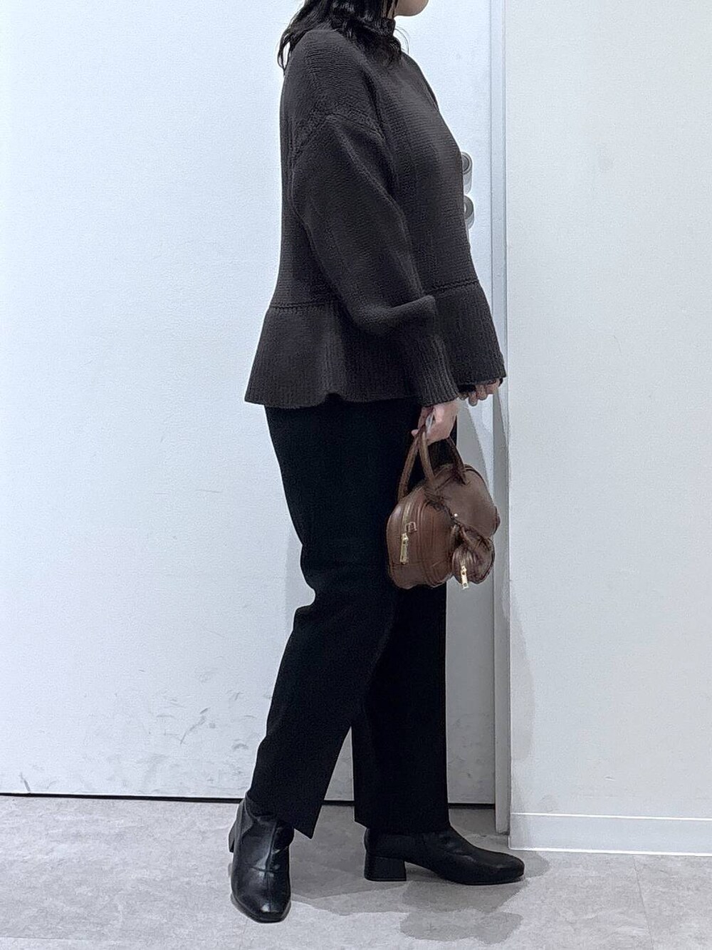ブラック系のその他パンツ、ブラック系のブーツ、ブラウン系のニット/セーターを着用したレディースの秋コーディネートの2枚目の写真