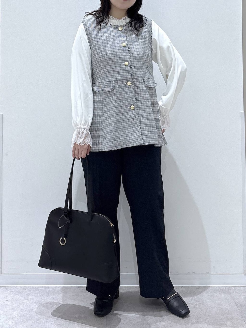 ブラック系のローファー、ホワイト系のシャツ/ブラウス、ブルー系のスラックスを着用したレディースの冬コーディネートの4枚目の写真