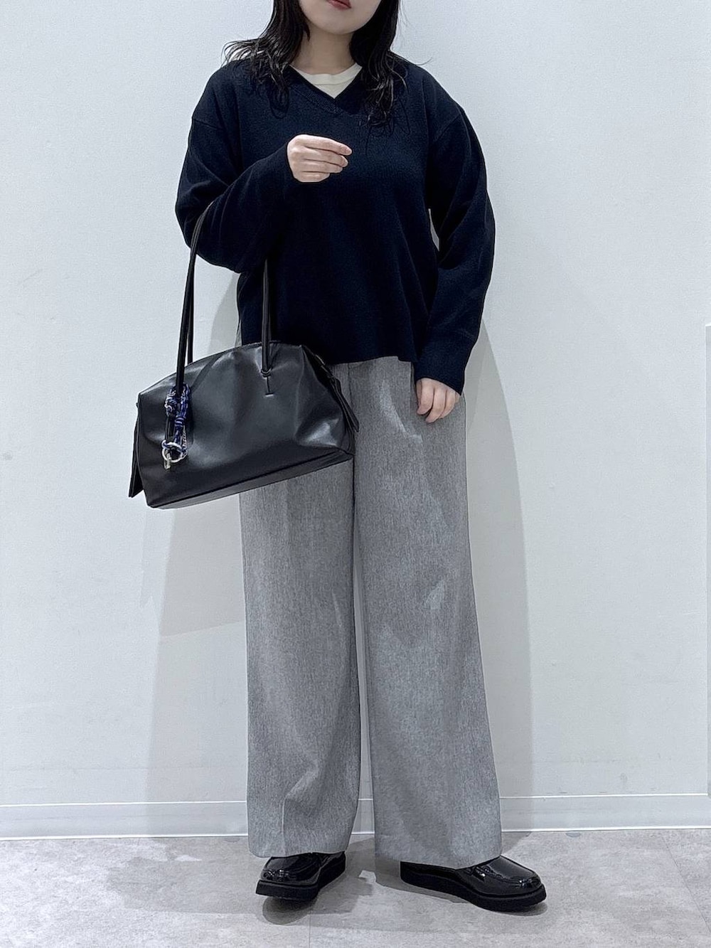 ブラック系のローファー、ブラック系のボストンバッグ、グレー系のその他パンツを着用したレディースの冬コーディネートの3枚目の写真