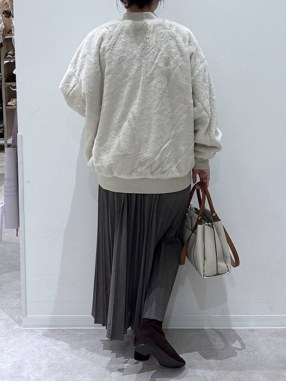 ベージュ系のブルゾン、ベージュ系のスカート、レッド系のニット/セーターを着用したレディースの冬コーディネートの3枚目の写真