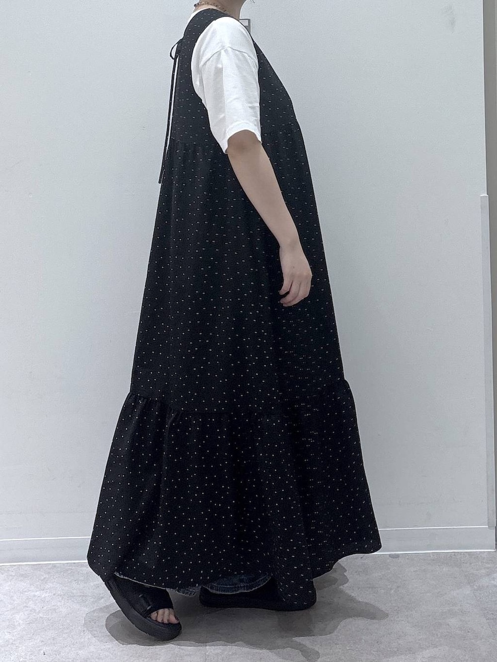 ブルー系のデニムパンツ、ブラック系のワンピース、ホワイト系のTシャツ/カットソーを着用したレディースの夏コーディネートの2枚目の写真