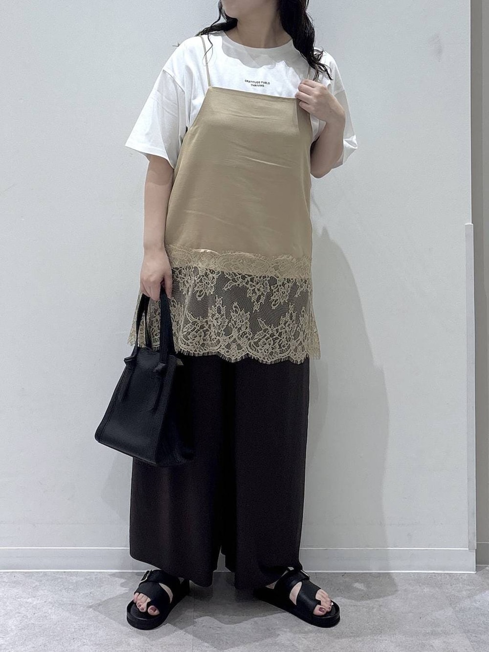 ブラック系のショルダーバッグ、ブラウン系のその他パンツ、ホワイト系のTシャツ/カットソーを着用したレディースの夏コーディネートの4枚目の写真