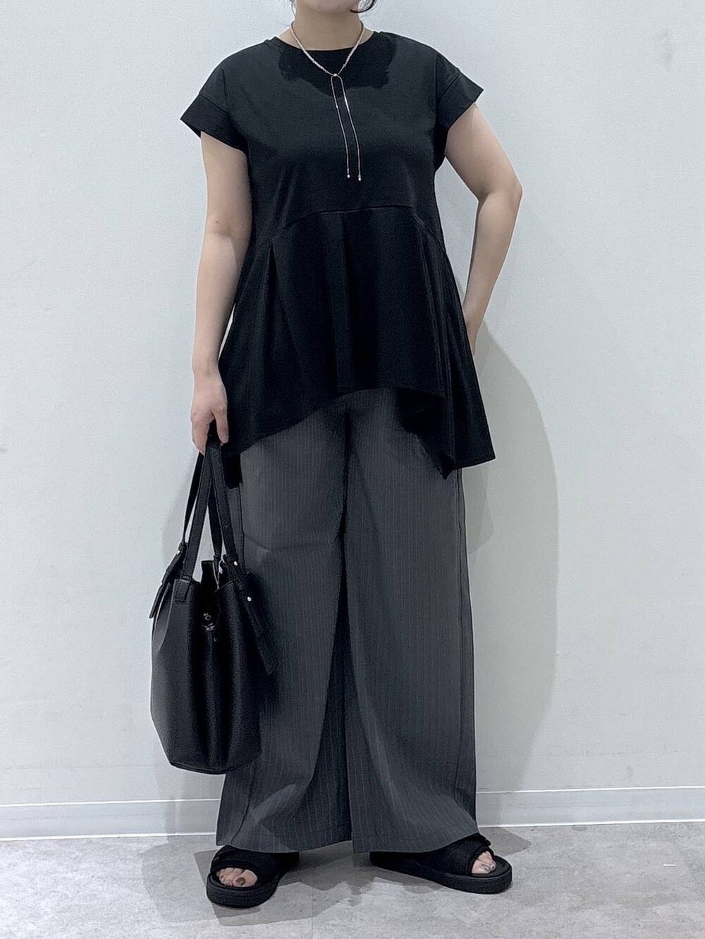 ブラック系のハンドバッグ、グレー系のその他パンツ、ブラック系のTシャツ/カットソーを着用したレディースの夏コーディネートの4枚目の写真
