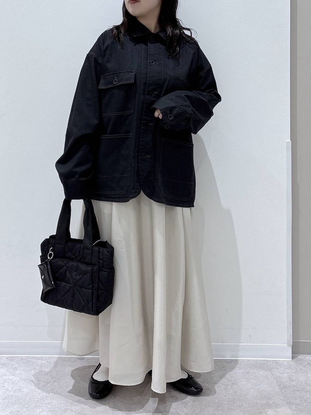 ブラック系のバレエシューズ、ブラック系のトートバッグ、ベージュ系のスカートを着用したレディースの春コーディネートの4枚目の写真