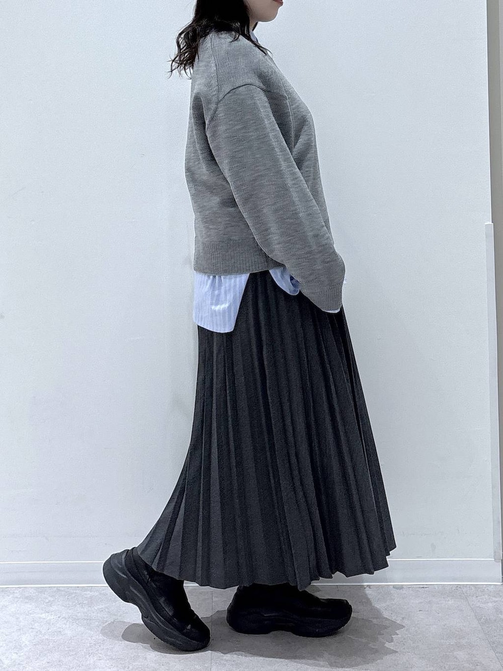 ブラック系のブーツ、グレー系のスカートを着用したレディースの冬コーディネートの2枚目の写真