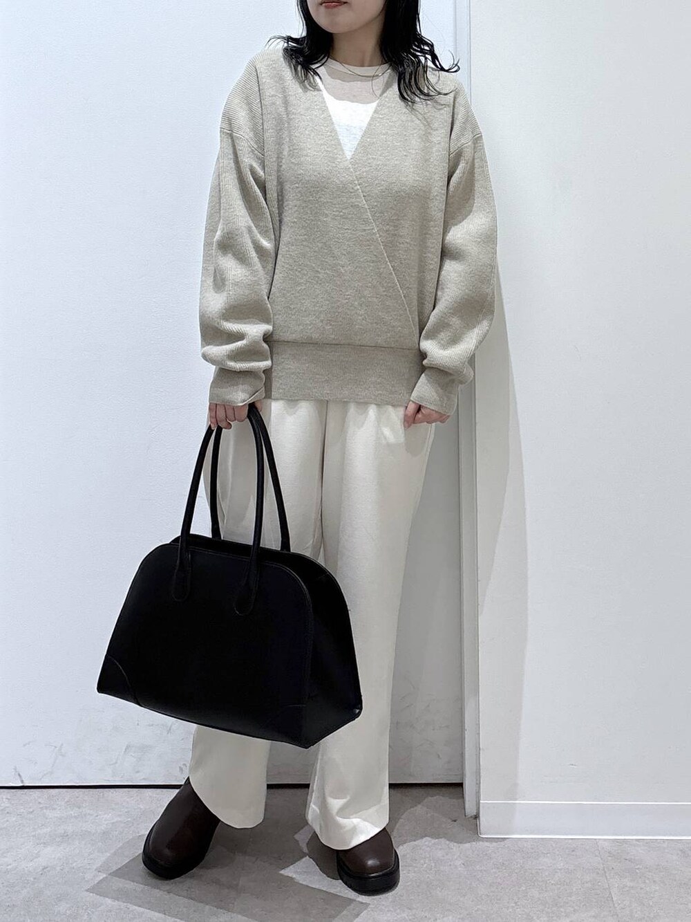 ブラック系のトートバッグ、ブラウン系のブーツ、グレー系のその他パンツを着用したレディースの冬コーディネートの3枚目の写真