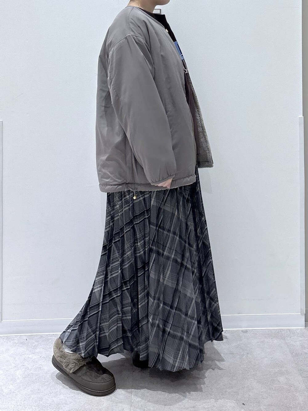 ブラウン系のブルゾン、ブラウン系のスウェット、グレー系のスカートを着用したレディースの秋コーディネートの2枚目の写真