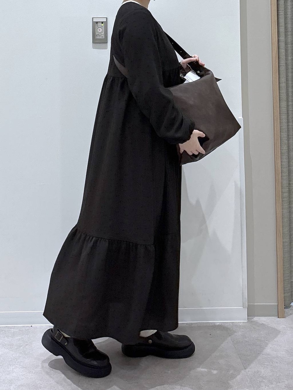 ブラウン系のショルダーバッグ、ブラウン系のワンピースを着用したレディースの冬コーディネートの2枚目の写真