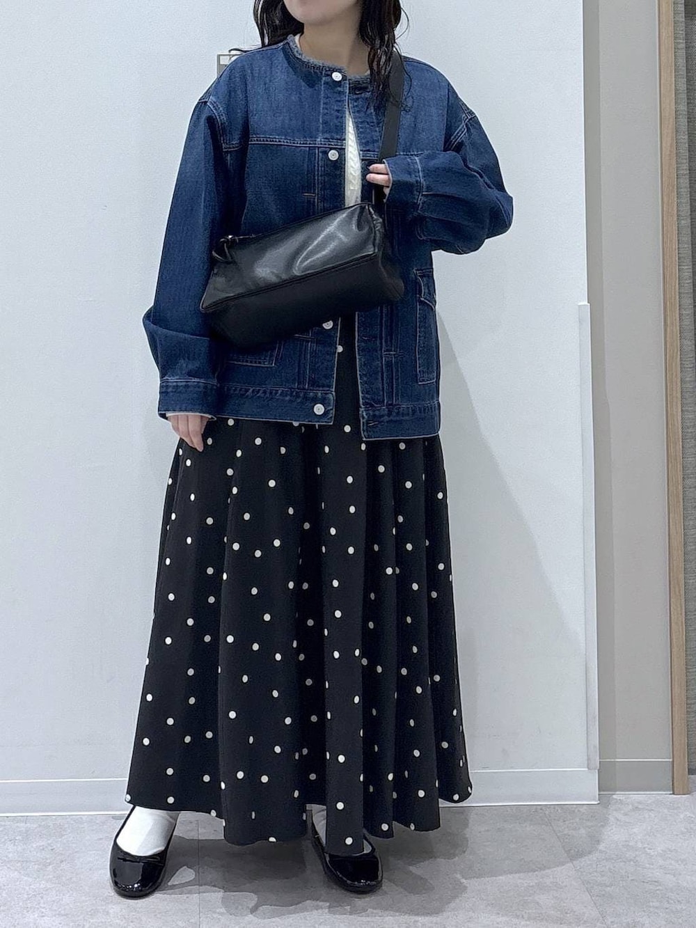 ブラック系のバレエシューズ、ブルー系のデニムジャケット、ホワイト系のニット/セーターを着用したレディースの冬コーディネートの4枚目の写真