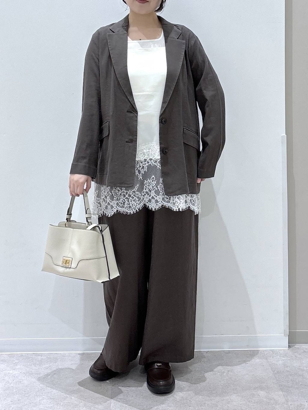 ブラウン系のその他パンツ、ブラウン系のテーラードジャケット、ベージュ系のショルダーバッグを着用したレディースの春コーディネートの4枚目の写真