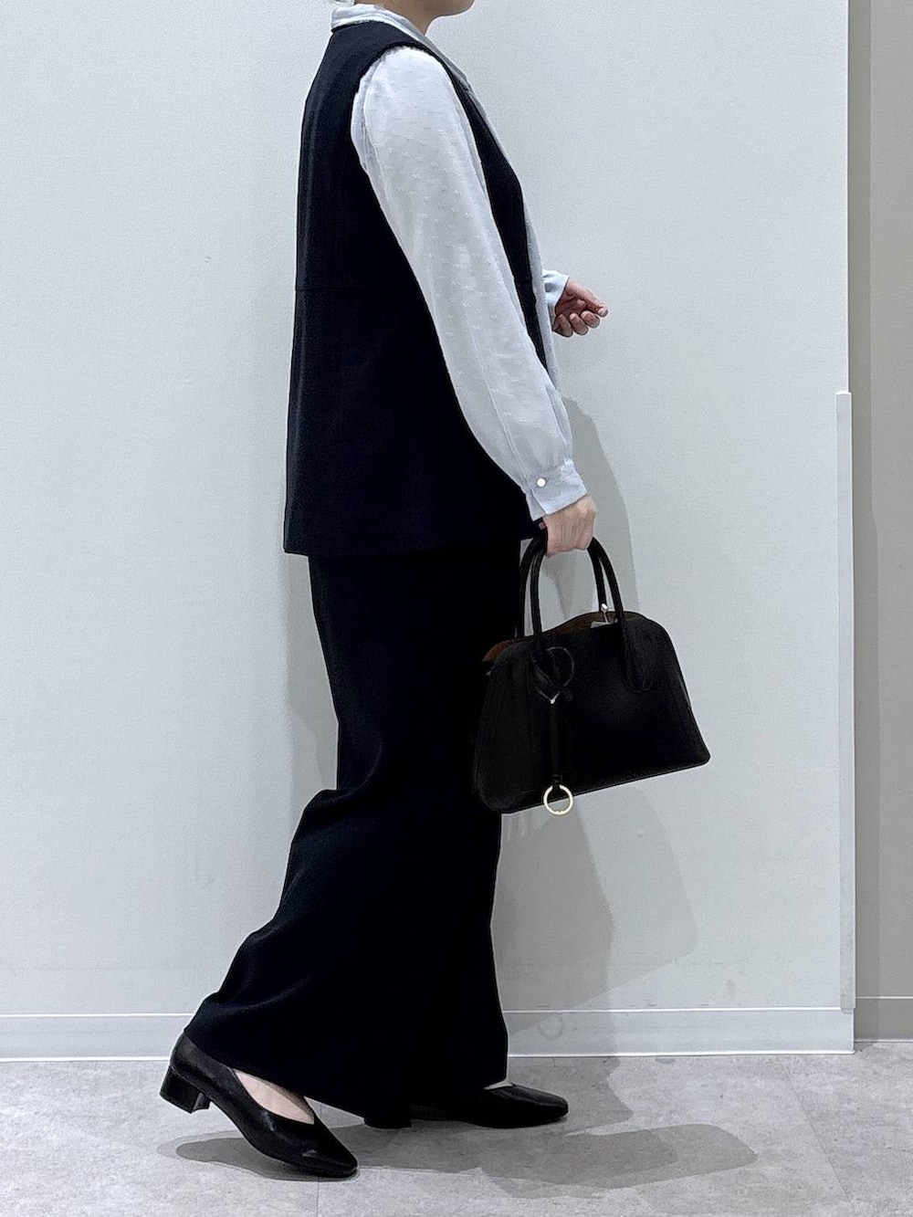 ブラック系のショルダーバッグ、ブラック系のパンプス、ブルー系のその他アウターを着用したレディースの冬コーディネートの2枚目の写真