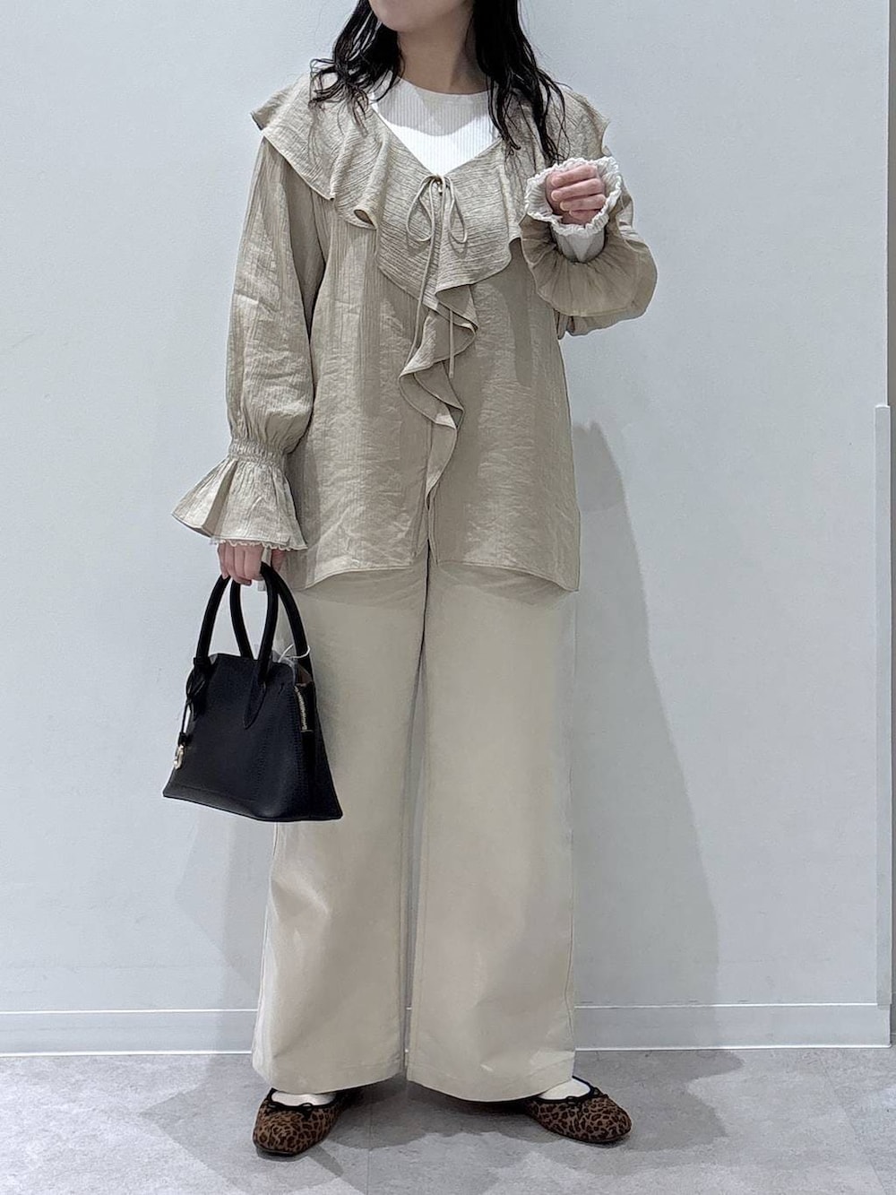 ブラック系のショルダーバッグ、ホワイト系のその他パンツ、ベージュ系のシャツ/ブラウスを着用したレディースの春コーディネートの4枚目の写真