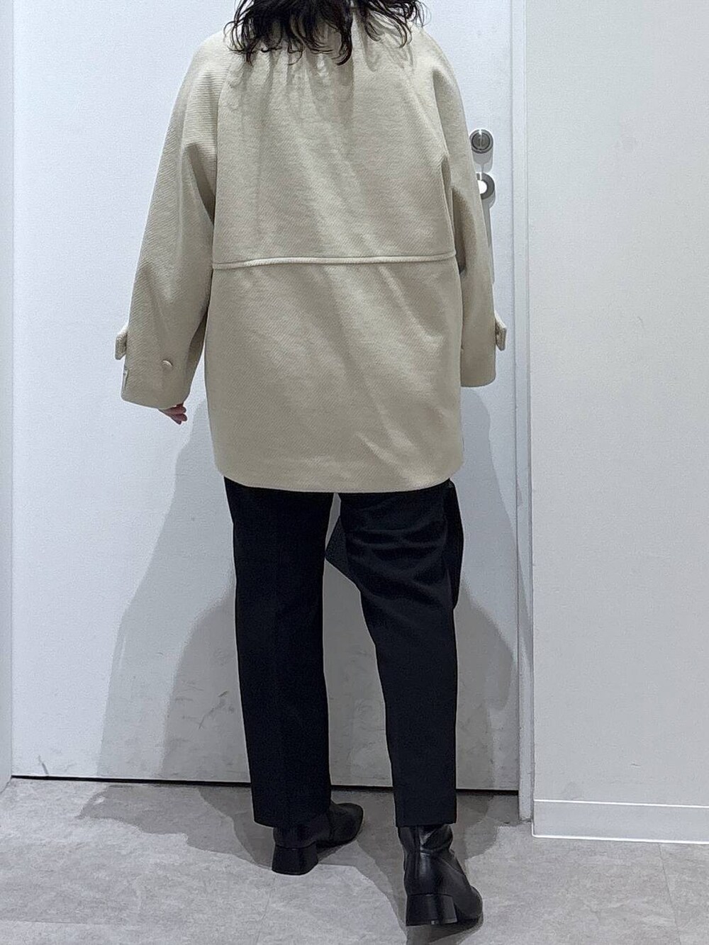 ブラック系のショルダーバッグ、ブラック系のその他パンツ、ホワイト系のステンカラーコートを着用したレディースの秋コーディネートの3枚目の写真