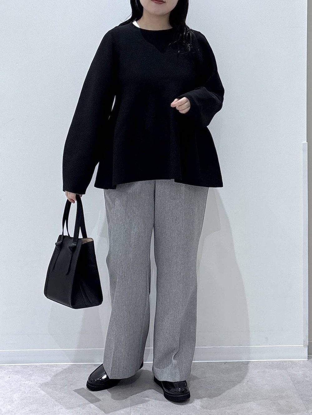 ブラック系のローファー、ブラック系のショルダーバッグ、グレー系のその他パンツを着用したレディースの冬コーディネートの4枚目の写真