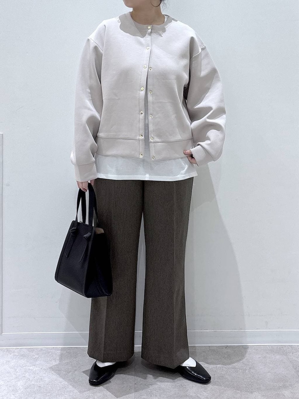 ブラック系のパンプス、ブラック系のショルダーバッグ、ブラウン系のその他パンツを着用したレディースの春コーディネートの5枚目の写真