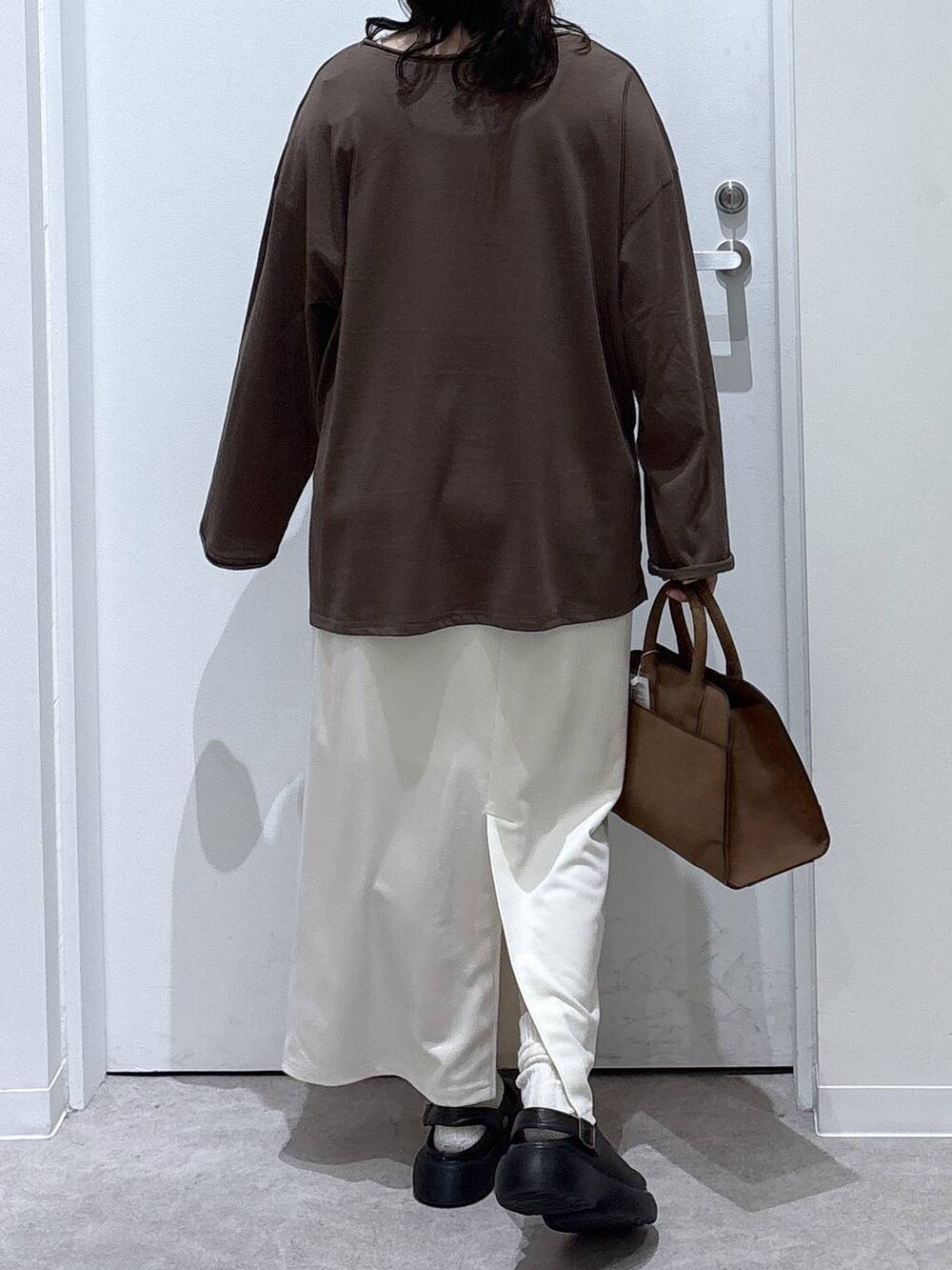 ベージュ系のショルダーバッグ、ベージュ系のスカート、ブラウン系のTシャツ/カットソーを着用したレディースの秋コーディネートの3枚目の写真