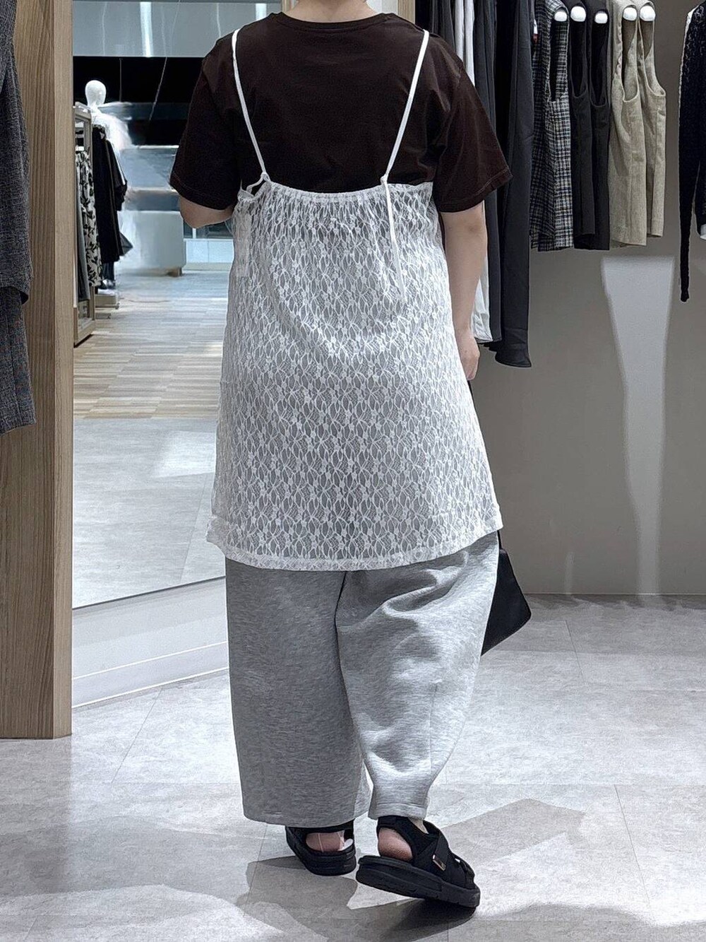 ブラウン系のショルダーバッグ、ブラウン系のTシャツ/カットソー、ブラック系のサンダルを着用したレディースの夏コーディネートの3枚目の写真